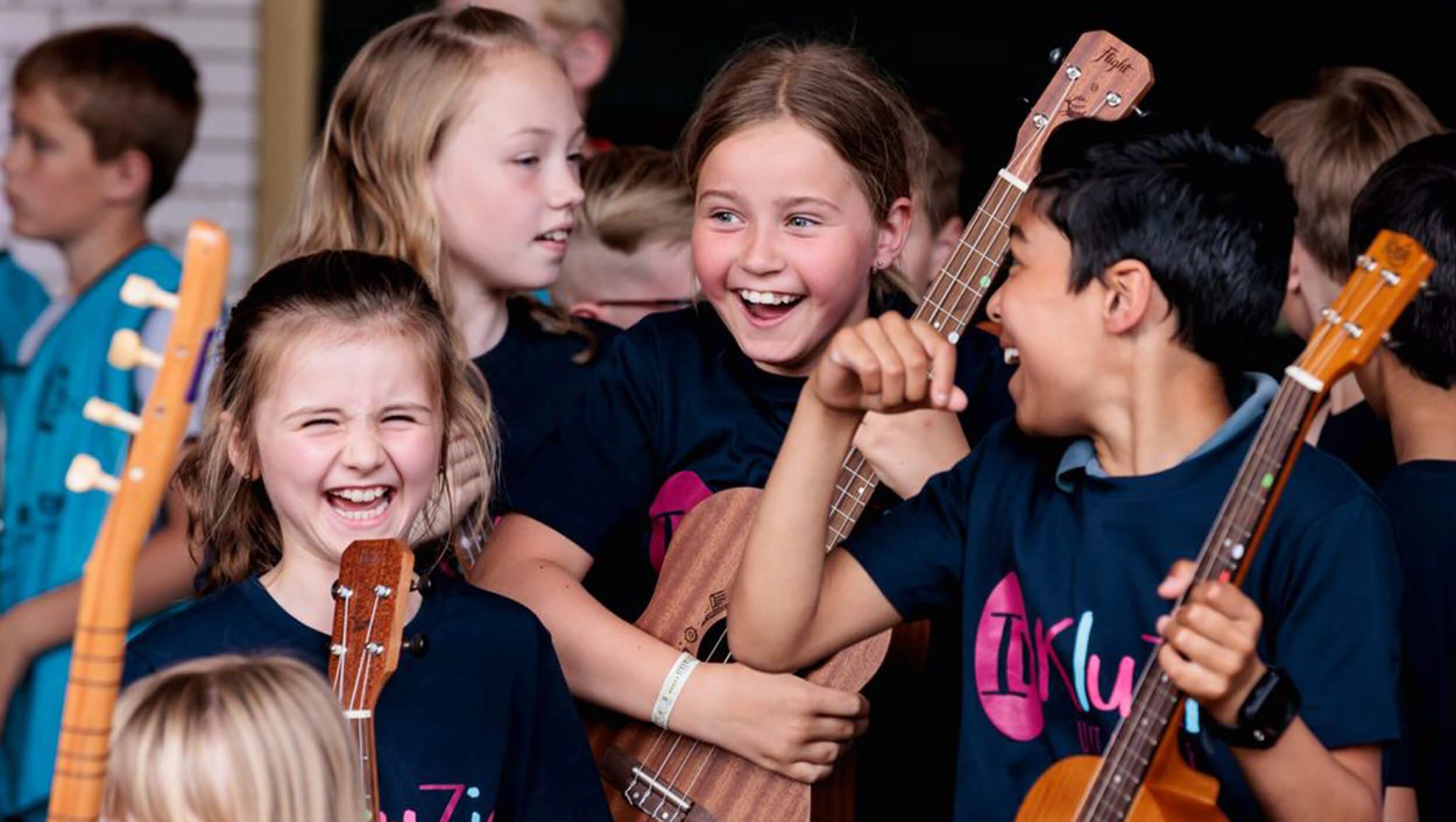Kinderen lachen met gitaren in de hand